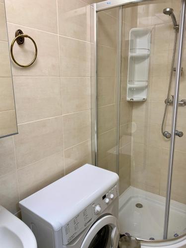 a bathroom with a shower and a washing machine at Apartman ZUPKO Filakovo in Lučenec