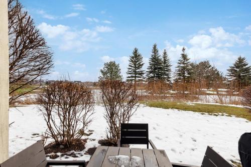 a wooden table and chair in the snow at Blue Mountain Retreat at Rivergrass in Blue Mountains