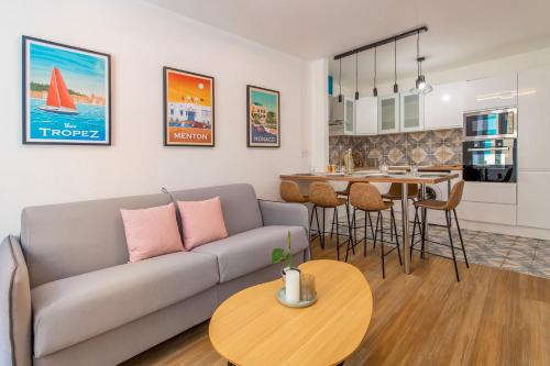 un salon et une cuisine avec un canapé et une table dans l'établissement ST MICHEL - Beau 3pièces en centre-ville climatisé, à Menton