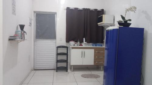 a kitchen with a blue refrigerator in a room at Loft 08 COMPLETO AR CANAIS ASSINAT GARAGEM in Pindamonhangaba