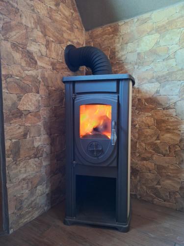a blue stove in a room with a stone wall at Kamp Kruščić - Laništa in Mojkovac
