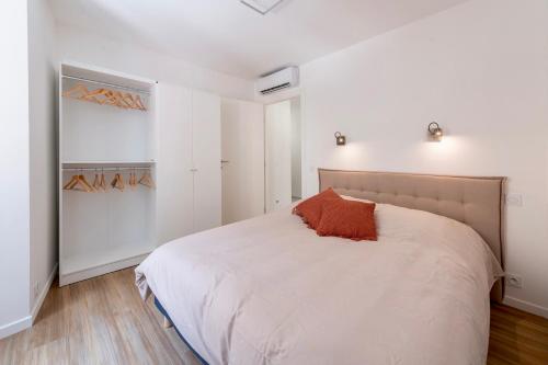 - une chambre avec un lit blanc et des murs blancs dans l'établissement ST MICHEL - Beau 3pièces en centre-ville climatisé, à Menton