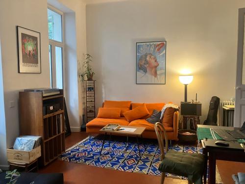 un salon avec un canapé orange et une table dans l'établissement Jardin à Marseille, à Marseille