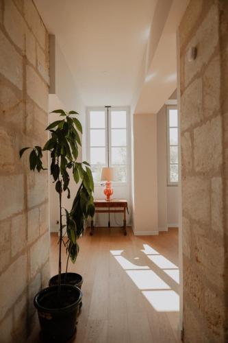 a room with a potted plant and a table at Chateau de la Vieille Chapelle in Lugon et l’Ile du Carney