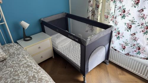 a black baby crib in a room with a bed at BALI House Bucharest in Bucharest