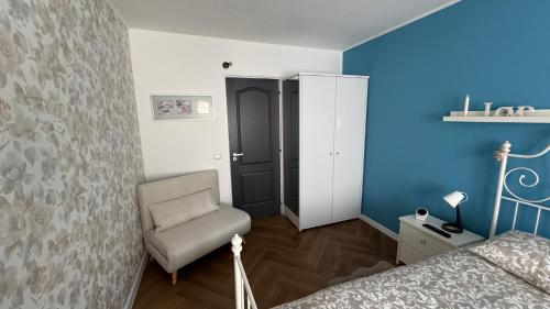 a bedroom with blue walls and a chair and a bed at BALI House Bucharest in Bucharest