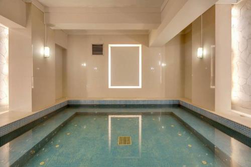 a swimming pool in a building with a window at Hotel Pangeran in Pekanbaru