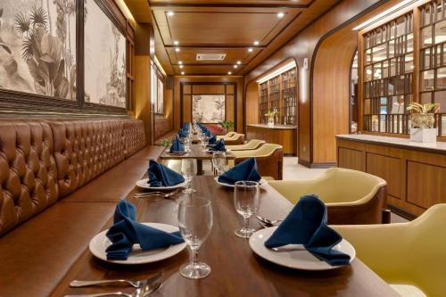 a dining room with a long table and chairs at Hotel Pangeran in Pekanbaru