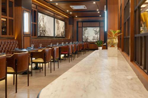 a dining room with tables and chairs at Hotel Pangeran in Pekanbaru