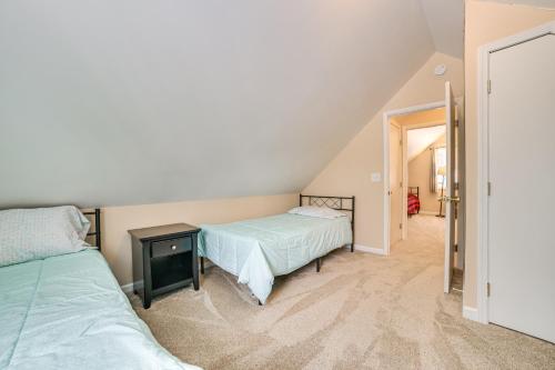 a attic bedroom with two beds and a hallway at 2 Blocks to Higgins Lake Family-Friendly Home in Roscommon