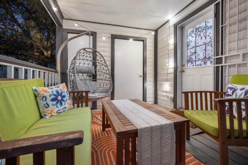 a porch with a swing and a table and chairs at Stylish, Artsy Bungalow Central Eastside in Austin