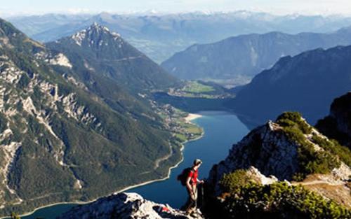 a person standing on top of a mountain overlooking a lake at Gästehaus Alpina in Maurach