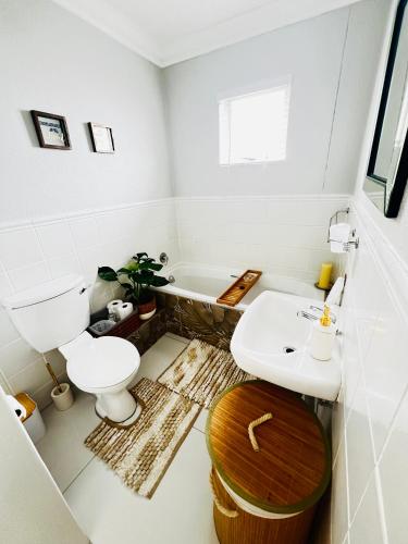 a bathroom with a toilet and a sink and a tub at 13 Chesapeake Bay in Margate