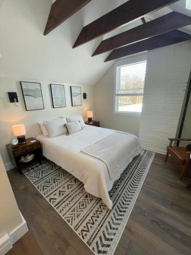 a bedroom with a large bed with a rug at The Innwoods - Studio Apartment 1 in Tannersville