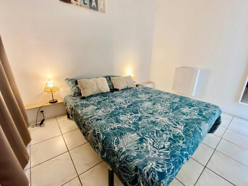 une chambre avec un lit avec une couverture bleue dans l'établissement St Martial Sète centre, CLIM, à Sète