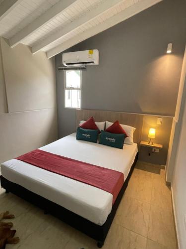 a bedroom with a large bed with red pillows at Hotel 12 Nights in Medellín