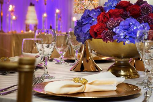a table with a vase of flowers and wine glasses at Twelve Midtown, Autograph Collection in Atlanta