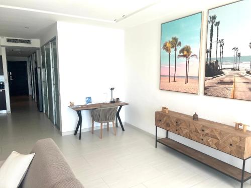 a living room with a table and a painting on the wall at Very luxury Waterfront apartment at Las Brisas in Koolbaai