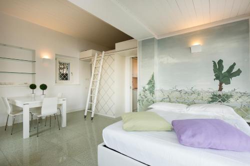 a bedroom with a bed and a table and a desk at Maison du Lac in Stresa
