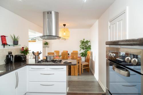a kitchen with white cabinets and a stove top oven at Tranquil Coastal Getaway Home in Saint Davids