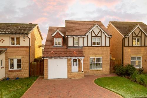 a brick house with a white garage at Tranquil Coastal Getaway Home in Saint Davids