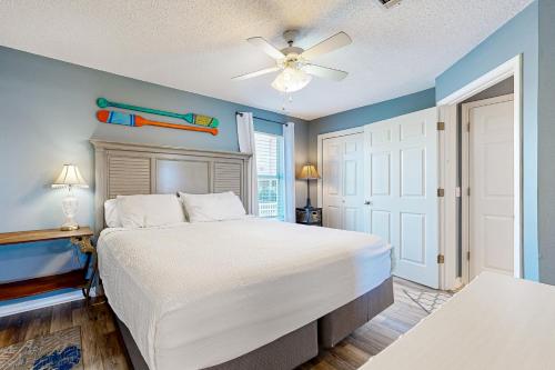 een slaapkamer met een bed en een plafondventilator bij Sunset Harbour Villas in Navarre