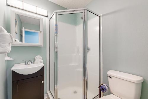 een badkamer met een douche, een toilet en een wastafel bij Sunset Harbour Villas in Navarre