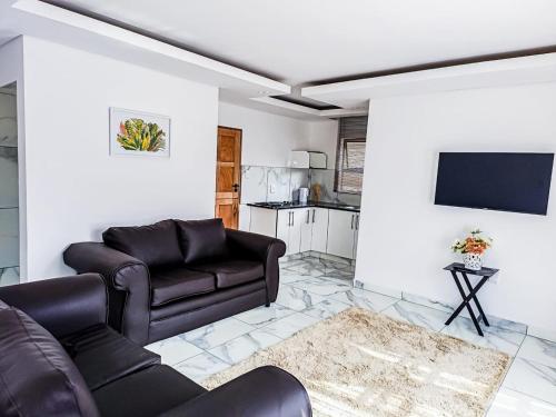 a living room with a couch and a tv at Eden Groove Luxury self catering Guesthouse in Matsulu