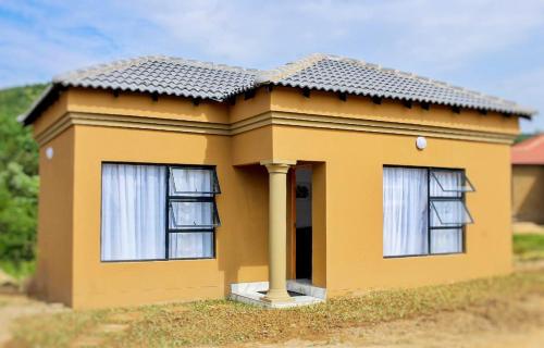 a model of a small yellow house with windows at Eden Groove Luxury self catering Guesthouse in Matsulu