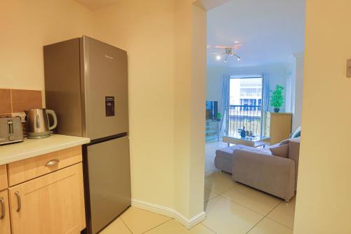 a kitchen with a refrigerator and a living room at Stadium View, by Cardiff Central, Free Parking in Cardiff