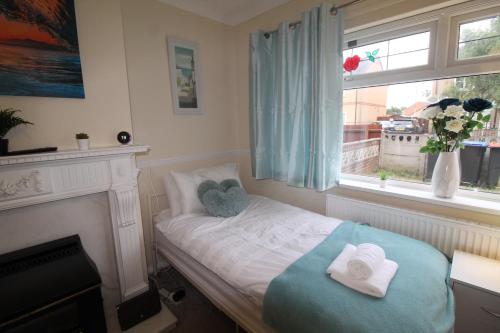 a bedroom with a bed with towels and a window at Sutton House in Sutton in Ashfield