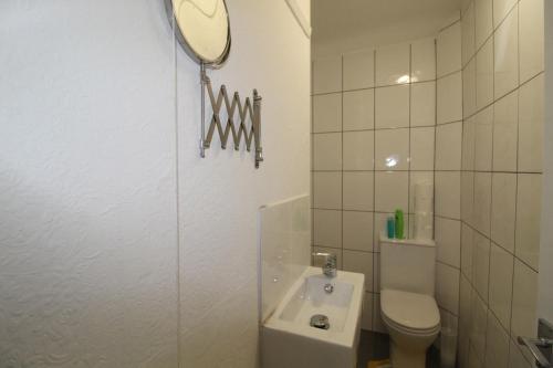 a bathroom with a toilet and a sink and a mirror at Sutton House in Sutton in Ashfield
