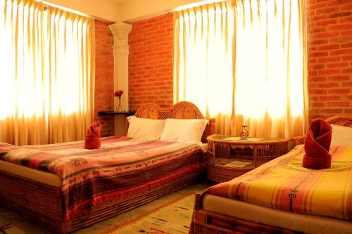 a bedroom with two beds and a window at Peace Eye Guest House in Pokhara