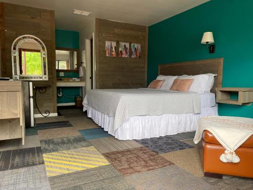 Un dormitorio con una cama y una pared verde. en Historic Mora Inn & RV Park, en Cleveland