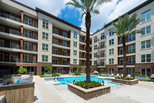 a large apartment building with a swimming pool and palm trees at Close to Everything in Downtown King bed Free Onsite Parking and WiFi in Houston