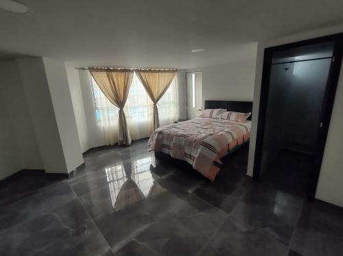 a bedroom with a bed and two windows at Hotel NOVA in Pasto
