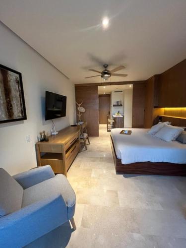 a bedroom with a bed and a couch and a tv at Beautiful Oceanview Apartment in Zantamar in Cruz de Huanacaxtle