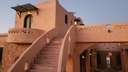 a stairway leading to a building with a staircase at Siwa Salt Lake Lodge in Siwa