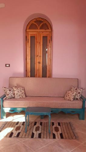 a couch sitting in a room with a mirror at Siwa Salt Lake Lodge in Siwa