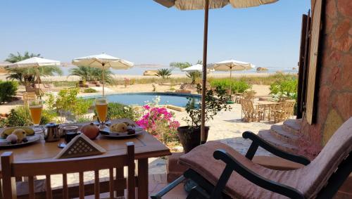 a table with food and a view of a pool at Siwa Salt Lake Lodge in Siwa