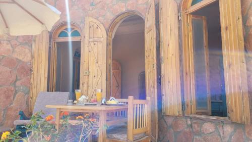 a table and a chair in front of a building at Siwa Salt Lake Lodge in Siwa