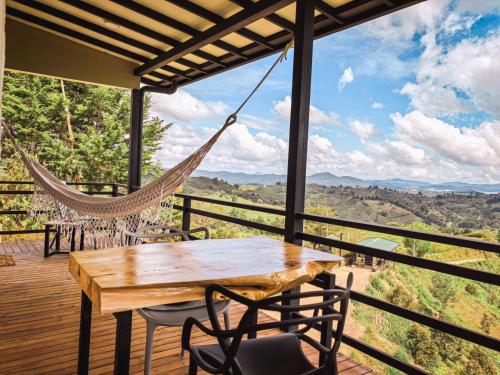 a porch with a hammock and a table and chairs at Alto Sereno in Horizonte