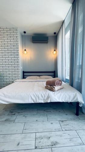 a bedroom with a large bed with two towels on it at Апартаменти студія в Гранд Бурже in Bucha