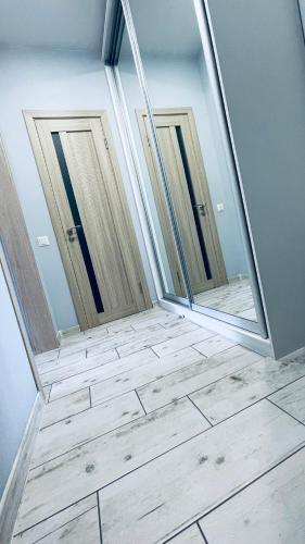 two mirrors in a room with a tile floor at Апартаменти студія в Гранд Бурже in Bucha