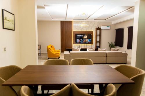 a living room with a table and chairs and a couch at Calini Luxury 2 Bedroom Flat - Sunflower Escape in Abuja