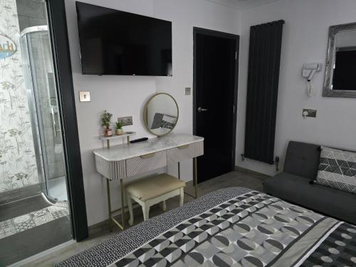 a bedroom with a sink and a mirror and a bed at Martello Bay Hotel in Clacton-on-Sea