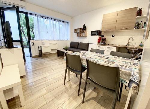 une cuisine et un salon avec une table et des chaises dans l'établissement LE PARC , Balaruc les bains T2 clim PMR, à Balaruc-les-Bains