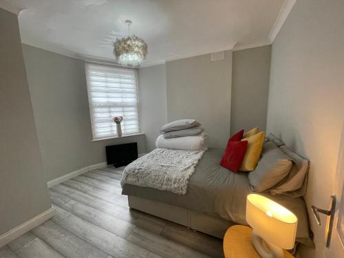 a bedroom with a bed with pillows and a chandelier at City Life Access Everywhere in London