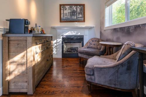a living room with two chairs and a fireplace at Brannan Cottage Inn in Calistoga