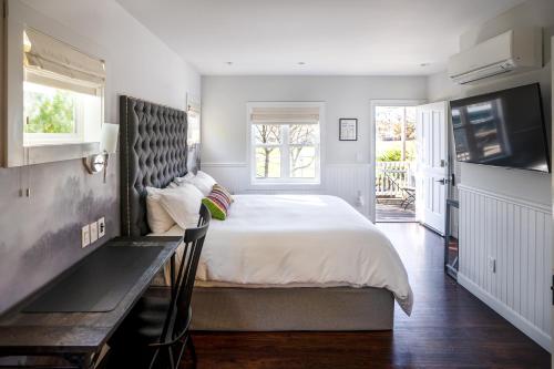 a bedroom with a large bed and a television at Brannan Cottage Inn in Calistoga